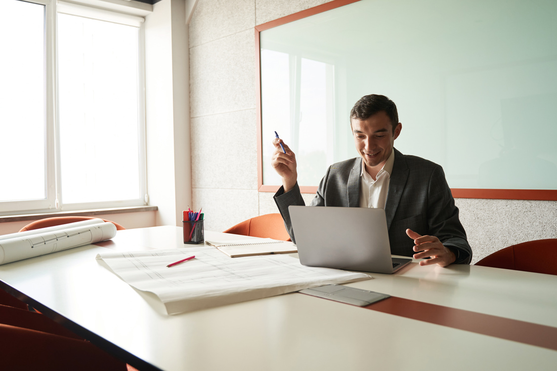 Building designer cheering up while using laptop in office